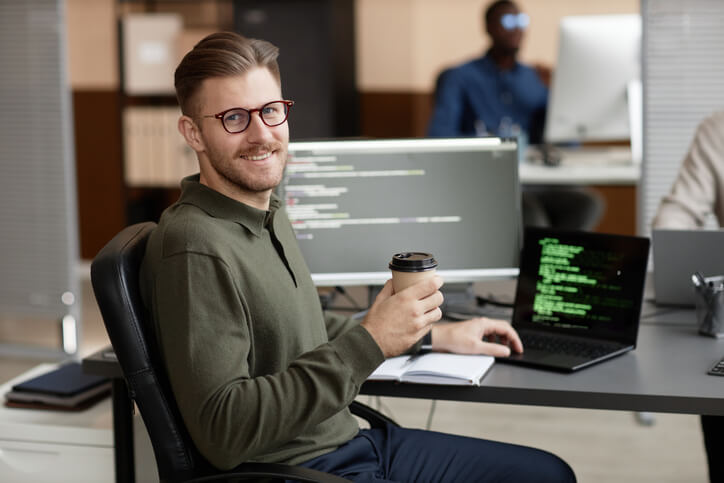  A male IT professional working in an office after completing his web developer training