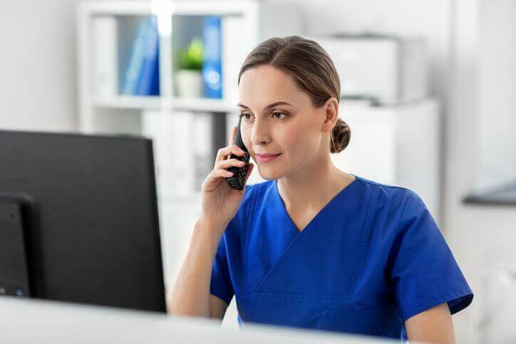 A career college graduate working in a health clinic at the computer