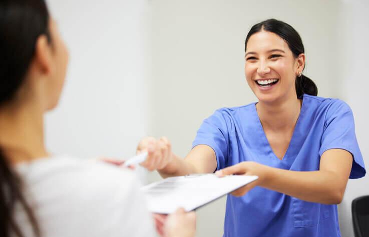 A female Certified Medical Assisting Professional reviewing patients’ medical histories alongside a male doctor