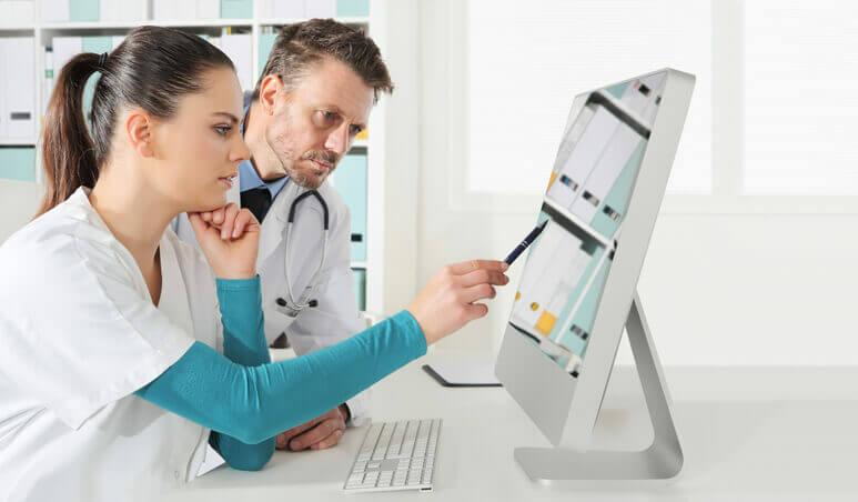  A smiling female Certified Medical Assistant handing a form to a patient at a hospital