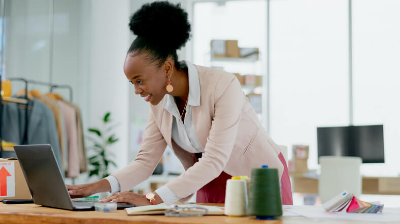 A cheerful e-commerce professional working from home after completing her business management training