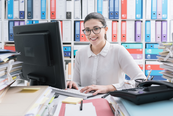  A smiling female accounting assistant working in an office after completing her accounting assistant training