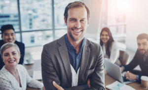 A confident and efficient male business leader with members of his team after business management training