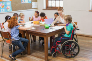 A female Educational Assistant helping pupils in a classroom