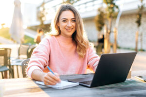 A smiling female educational assistant working on a computer at a school