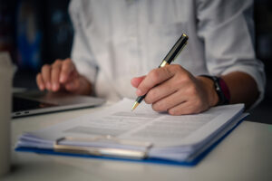 A focused male Community Service Worker writing a report