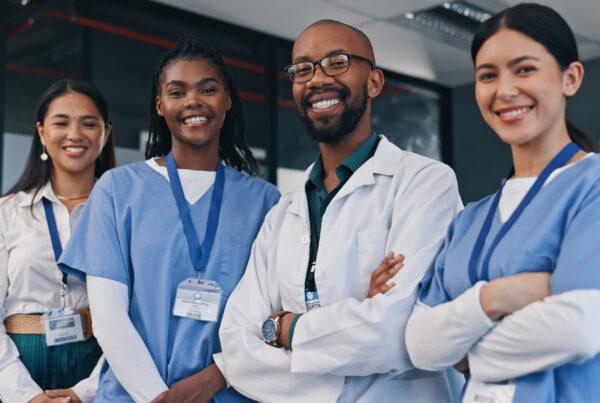 A smiling female health care aide with other members of a healthcare team
