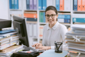 Smiling female accounting clerk in an office after completing her accounting administration training