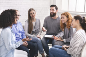 A male community service and addictions worker in a group discussion with clients 