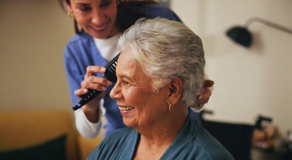 A health care aide assisting a senior with daily care