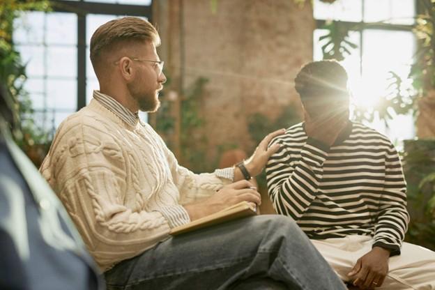 A male addictions support worker interacting with an agitated client 