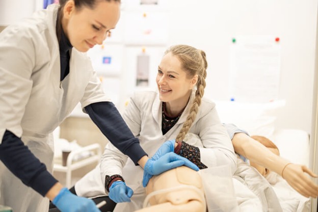 A student practicing elder care support in a training lab