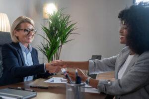 An administrative assistant greeting a client in an office