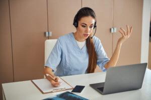 A Medical Office Assistant helping a patient with digital check-in for a telehealth appointment