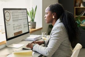 An accounting administration graduate reconciling accounts on a computer