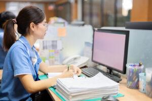 A medical office assistant coordinating patient records during clinical care