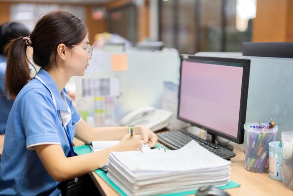 A medical office assistant coordinating patient records during clinical care