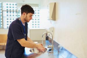 A health care aide training graduate performing proper hand hygiene in a care setting 