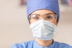 A health care aide training graduate wearing PPE while assisting a client