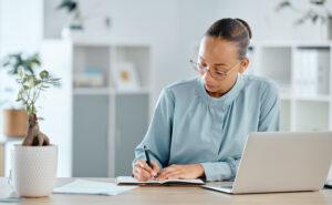 Community service worker editing case notes to remove subjective language and focus on observable facts, demonstrating one of the documentation and case note tips for community service workers