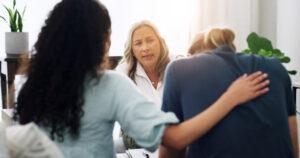 A community service worker speaking with a family about addiction recovery support options