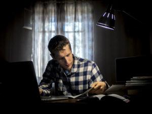 An adult student studying at night after a full workday, representing studying while working full-time