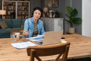 An adult student attending an online class from home using a laptop