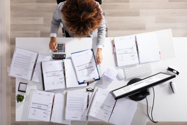 Accounting assistant preparing spreadsheets and invoices for audit review