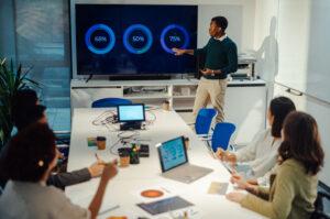 An IT professional presenting network performance updates during a team meeting
