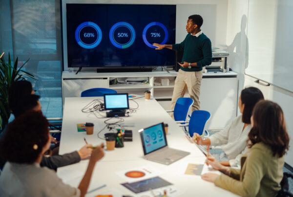 An IT professional presenting network performance updates during a team meeting